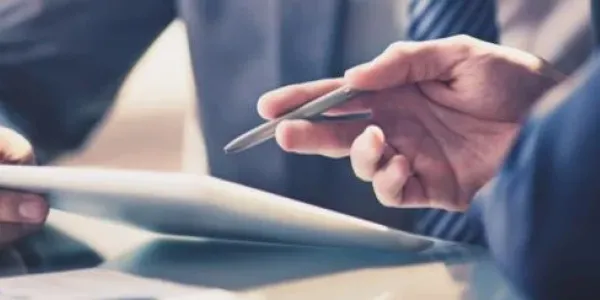 two people signing a document