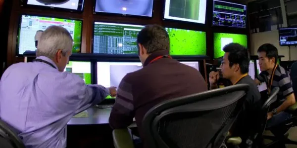 people working on a control room in front of screens