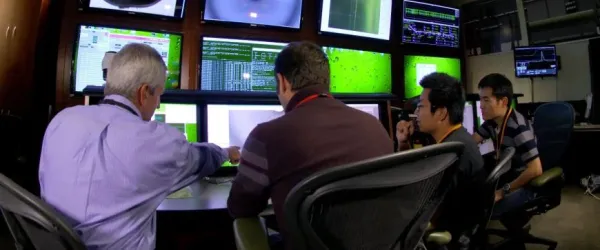 people working on a control room in front of screens
